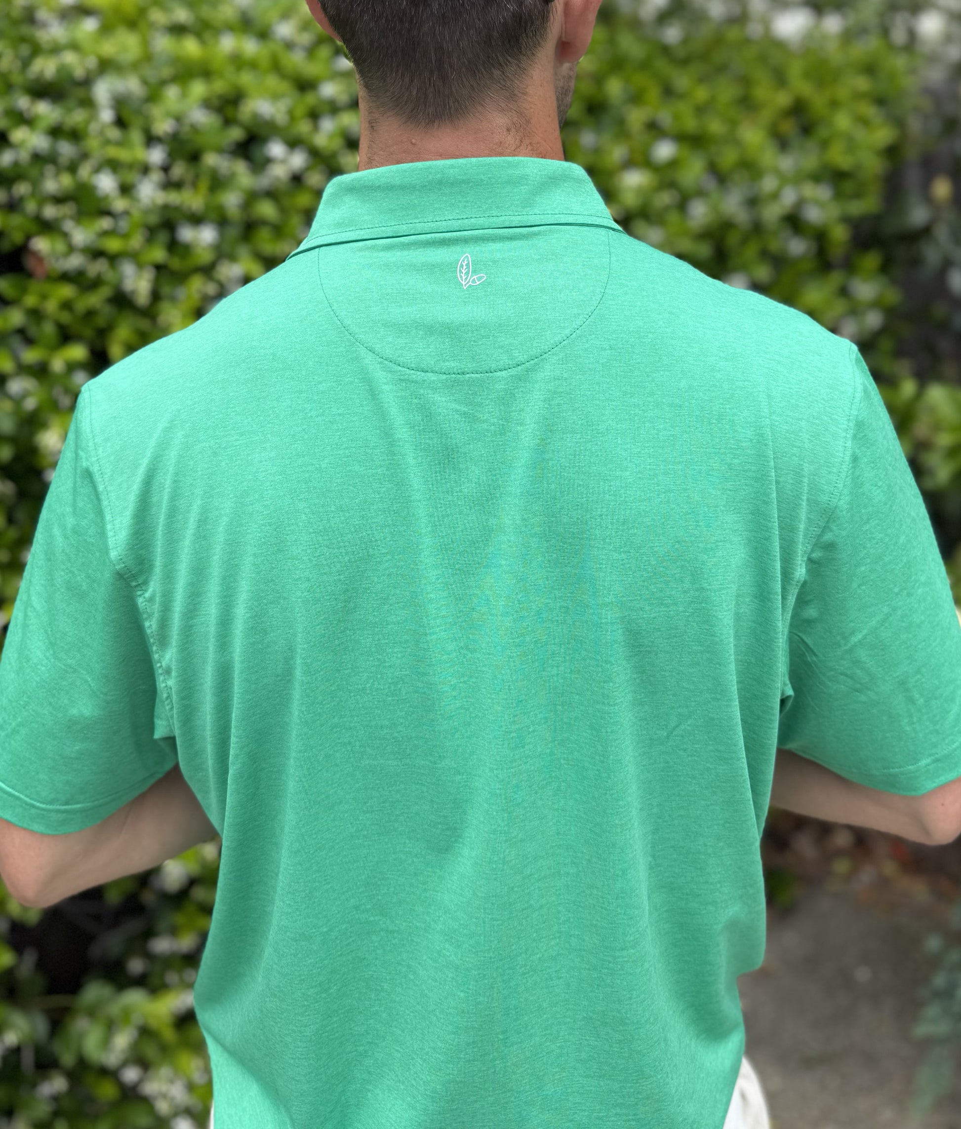 Man wearing Alon's Cafe green Bond Polo with leaf and acorn heat transfer logo.