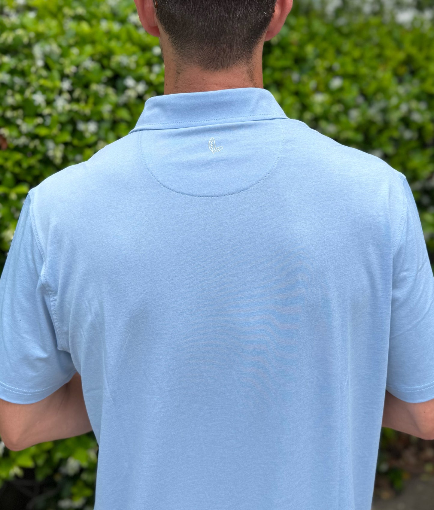 Man wearing Alon's Porch Ceiling light blue Bond Polo with leaf and acorn heat transfer logo.