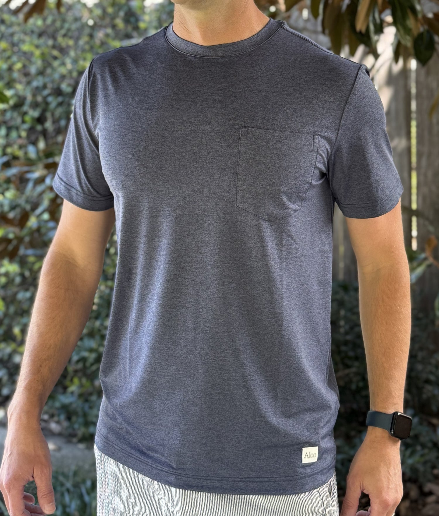 Alon's "Lagoon" Shades of NOLA Pro Pocket Tee in deep blue heather fabric with 4-way stretch and moisture wicking properties. 