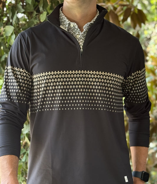 A man wearing a black quarter zip with a New Orleans Saints themed gold fleurs-de-lis pattern