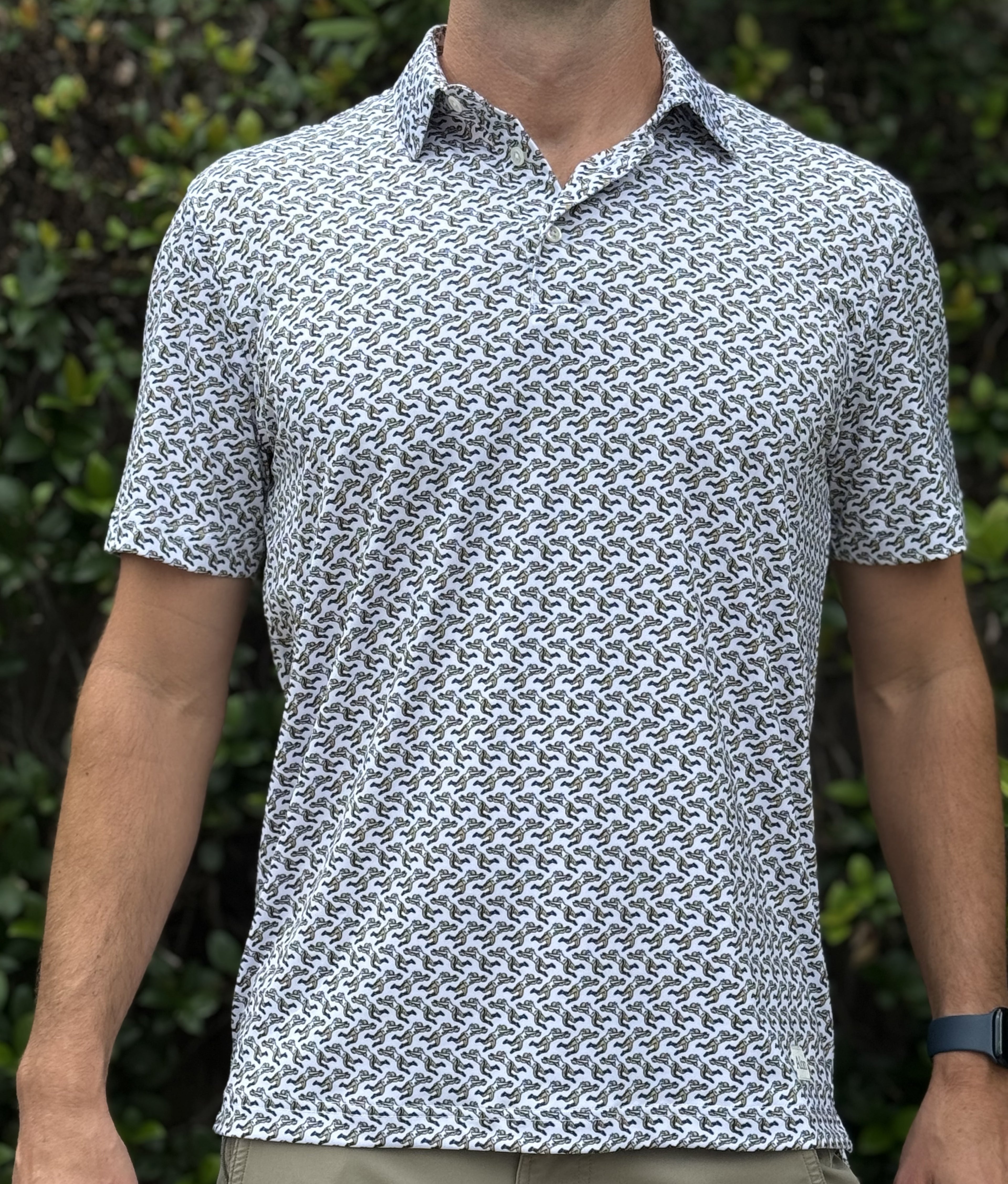 Man wearing a patterned polo shirt that features the famous Rebirth blocked punt for the New Orleans Saints
