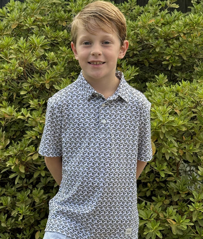 A young boy wearing a New Orleans Saints patterned polo