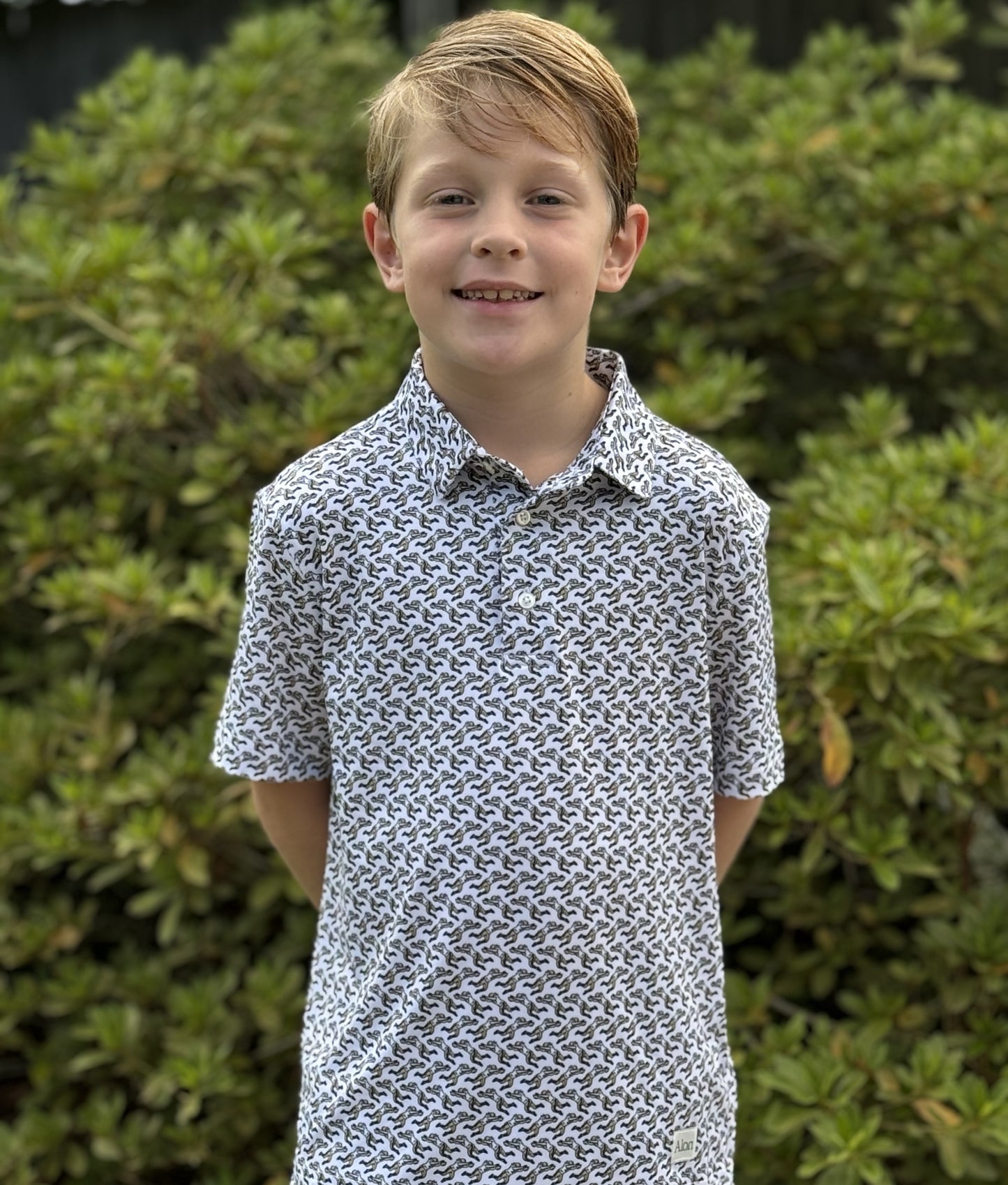 A young boy wearing a New Orleans Saints patterned polo