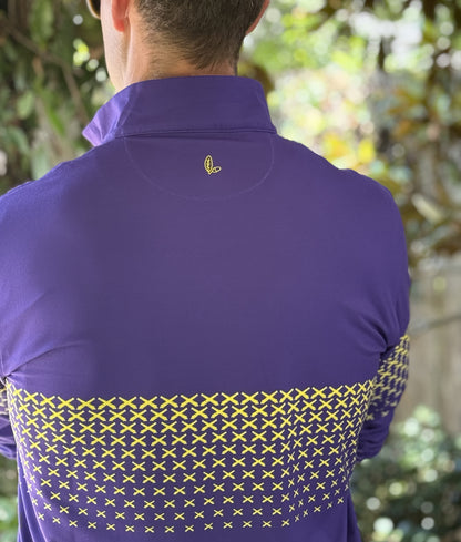 A man wearing a purple quarter zip with a gold LSU themed cannon pattern.