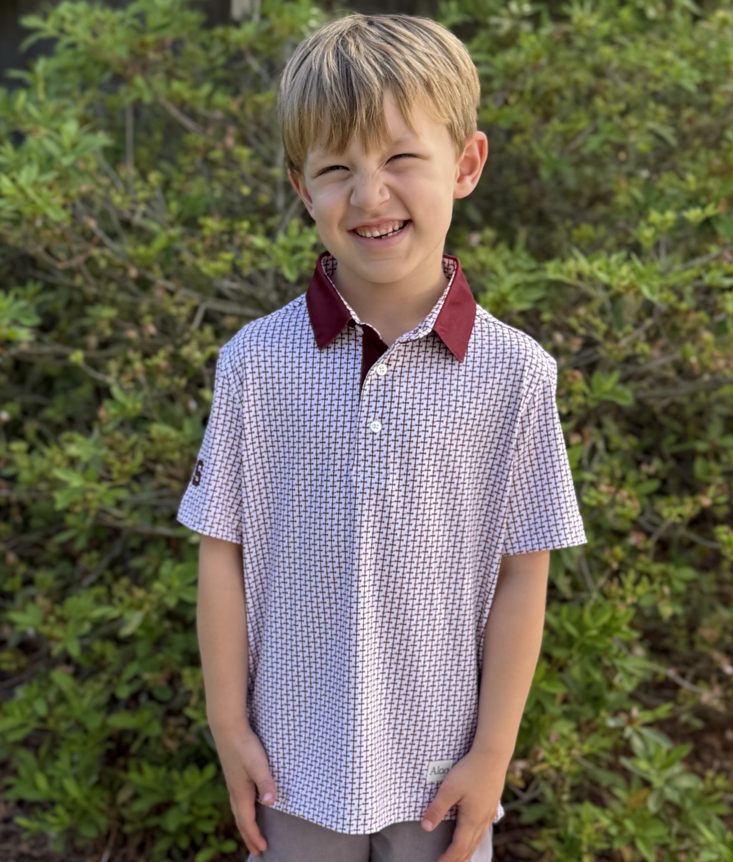 Crimson colored Lasallian cross patterned polo over white fabric with CBS heat transfer detail.