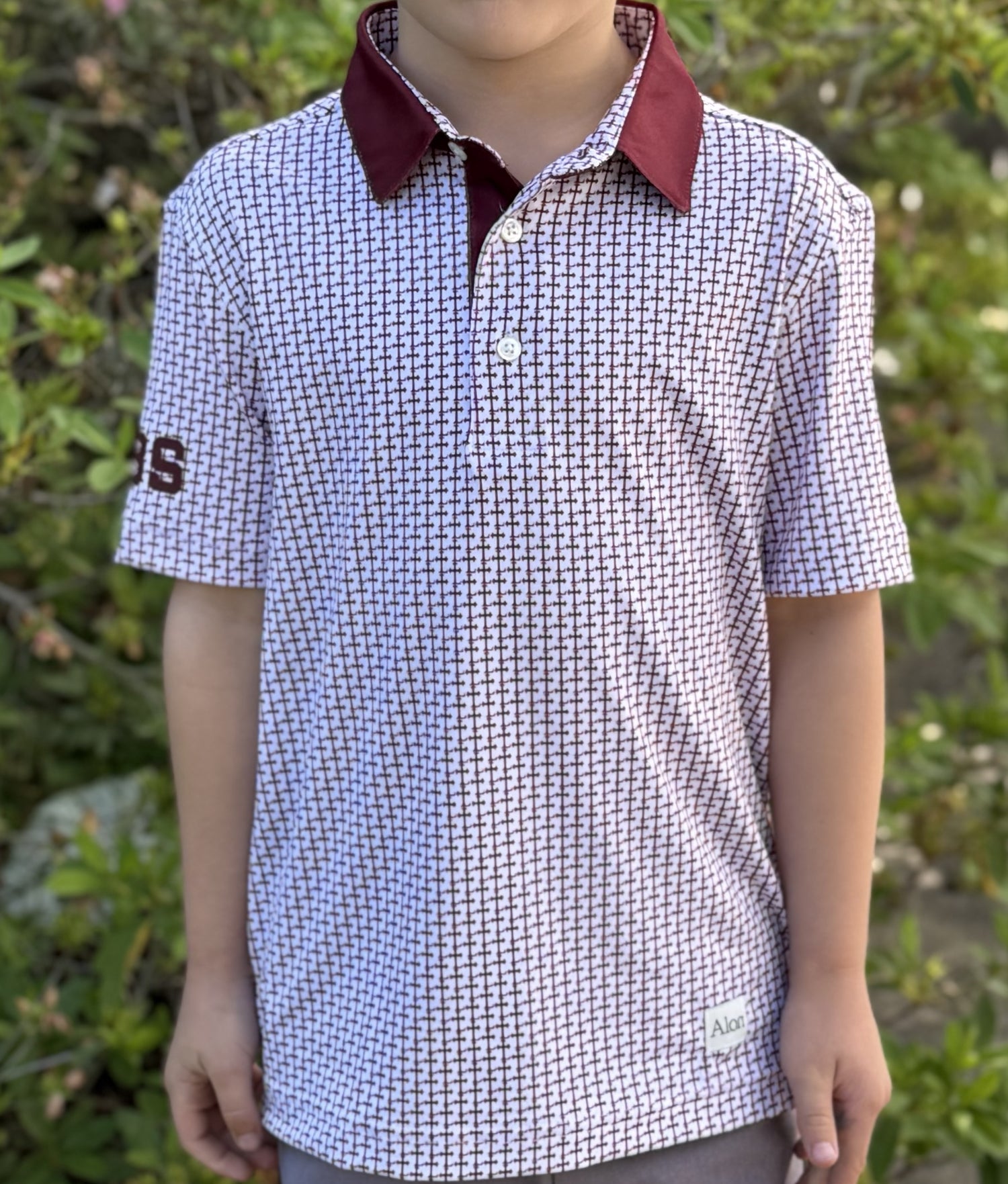 Crimson colored Lasallian cross patterned polo over white fabric with CBS heat transfer detail.